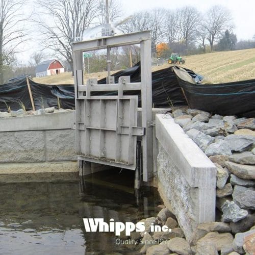 Custom stainless steel water control gate installed in an agricultural irrigation system.