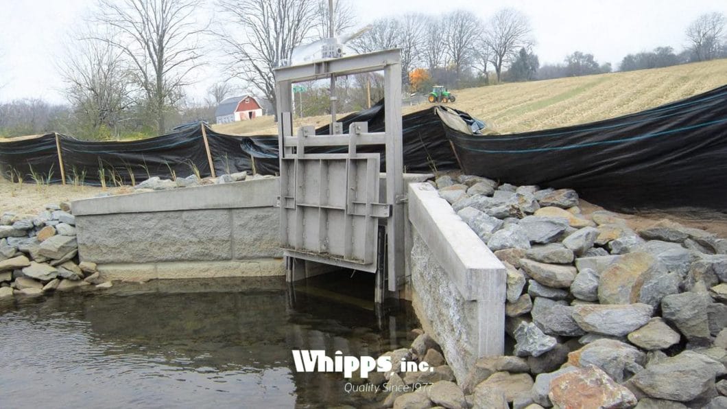 Custom stainless steel water control gate installed in an agricultural irrigation system.