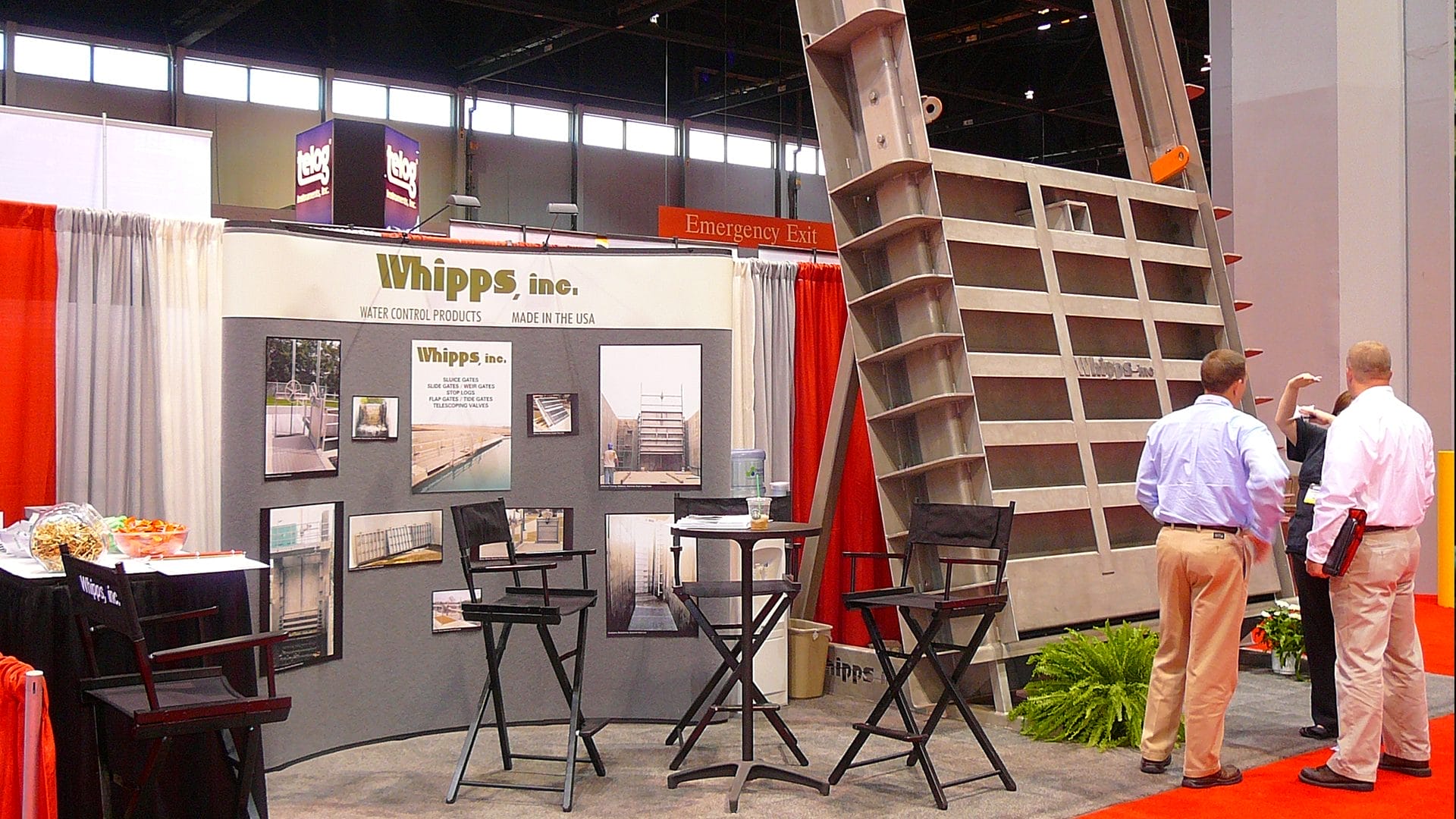Whipps, Inc. trade show booth at WEFTEC 2008 displaying a large stainless steel water control gate, with attendees engaging in discussions.
