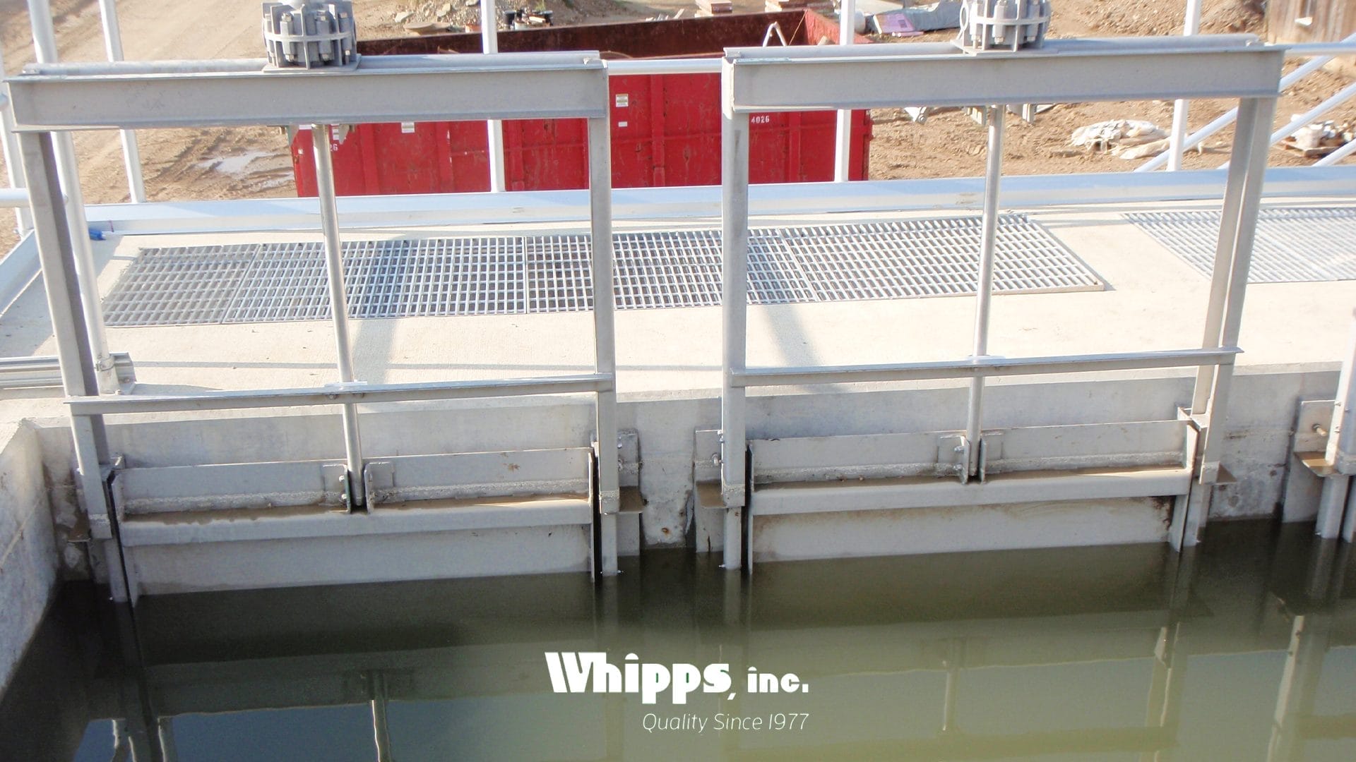 Stainless steel slide gate installed in a concrete channel at an Ohio wastewater treatment plant, submerged in turbulent water with visible foam and debris.
